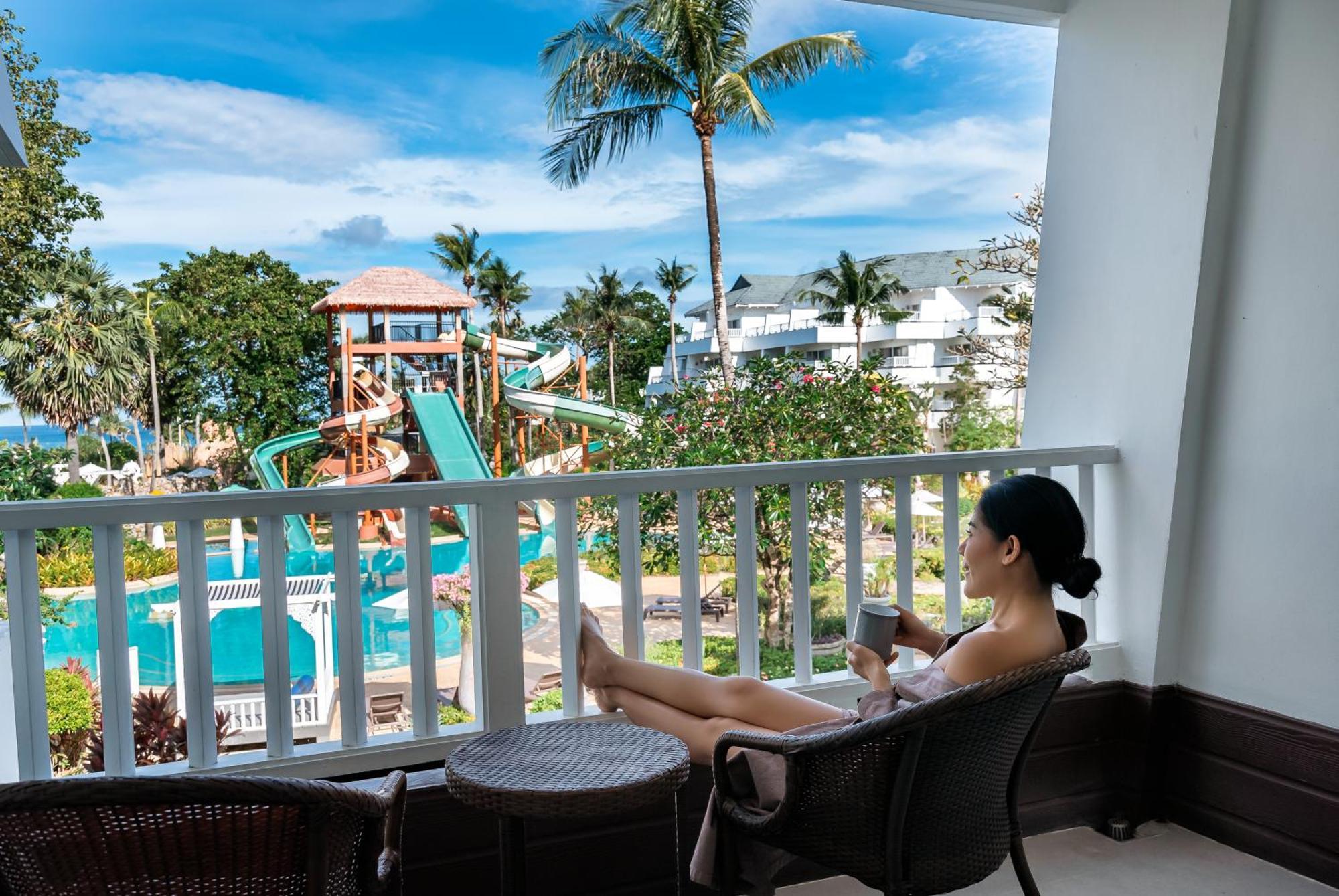 Thavorn Palm Beach Resort Phuket Karon Esterno foto A woman relaxing on a balcony