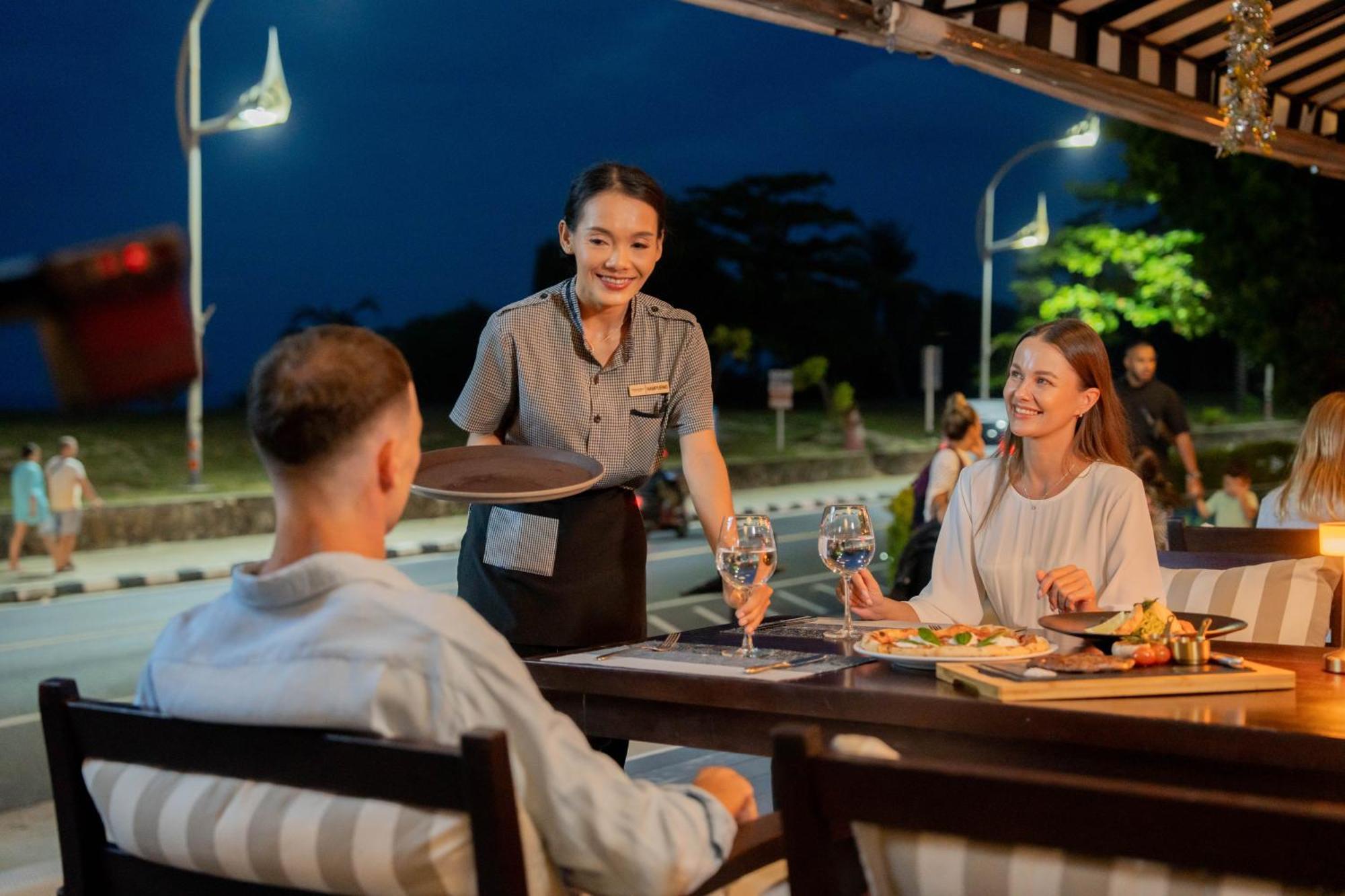 Thavorn Palm Beach Resort Phuket Karon Esterno foto A waitress serving guests at a restaurant